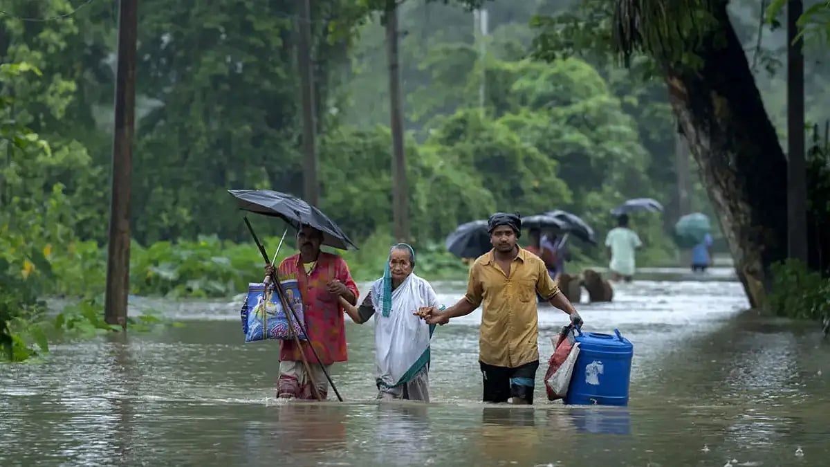 Villagers wade through floodwaters to a safer place in Rangia, west of Guwahati.