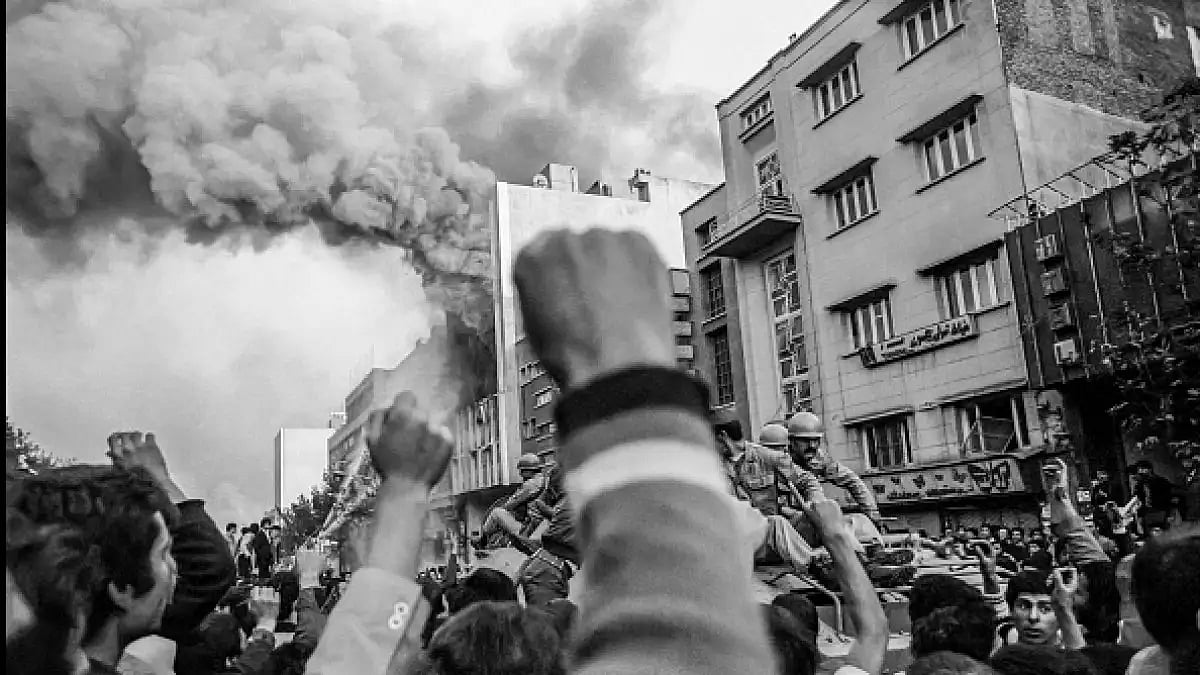Troops loyal to Shah Mohammad Reza Pahlavi arrive to control a crowd of demonstrators in Tehran.