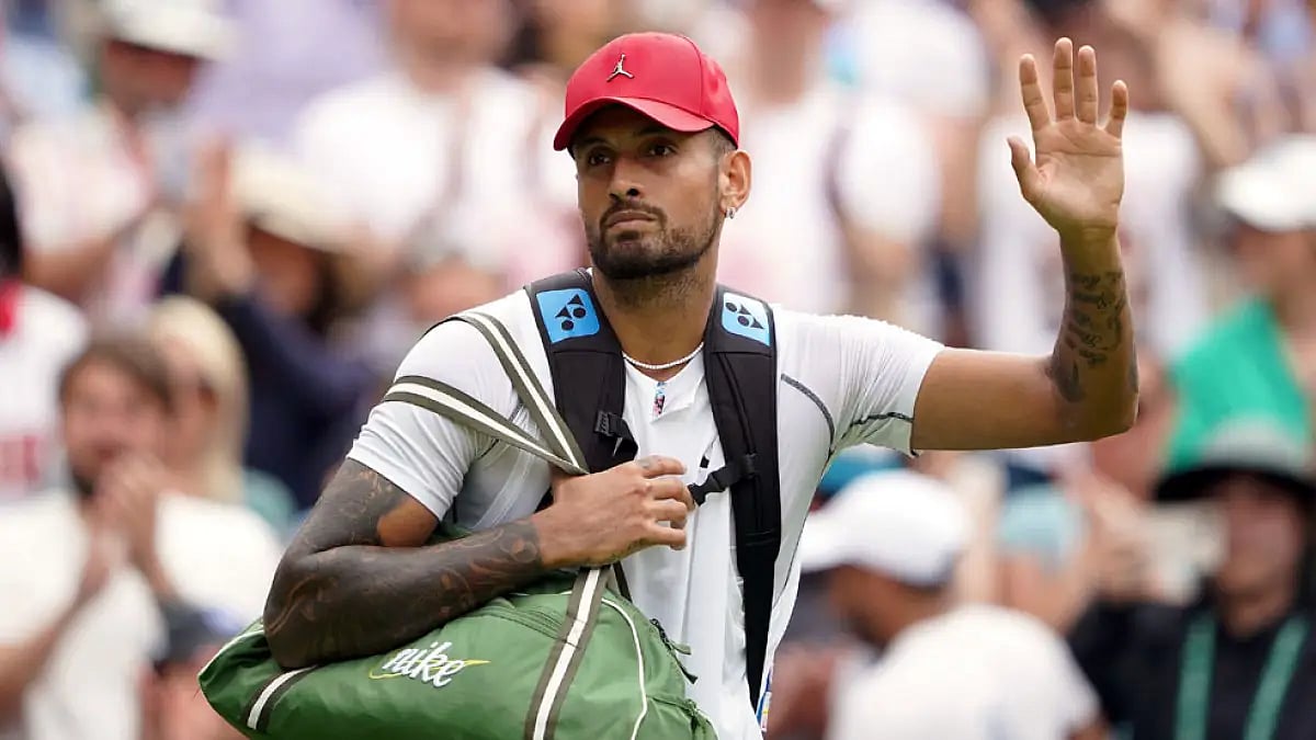 Nick Kyrgios waves as he walks off court after beating Brandon Nakashima at Wimbledon 2022.