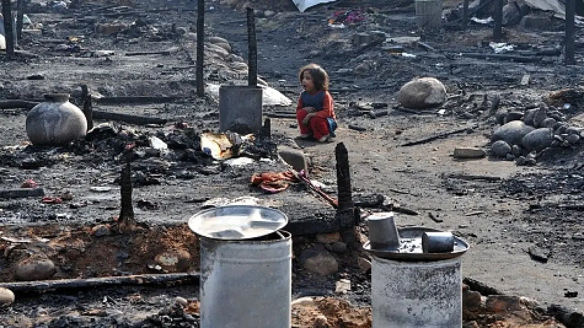A Myanmar refugee lady looks for belongings after a fire at slum area outskirts of Jammu | - null