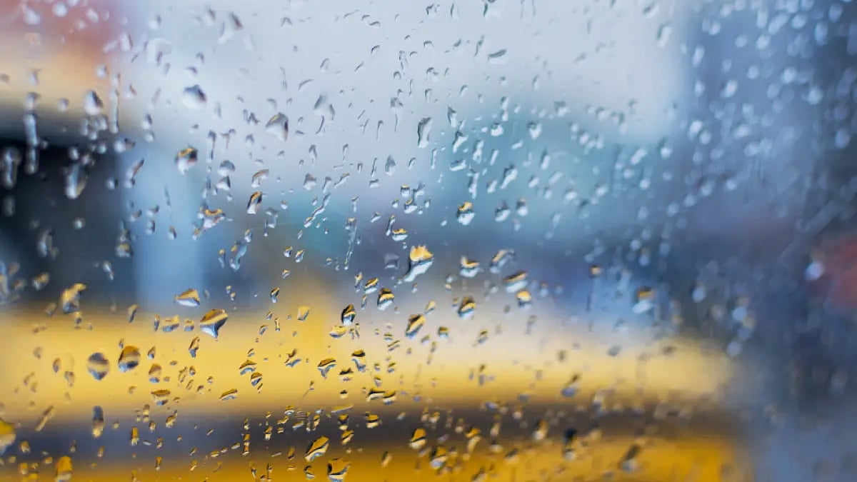 Raindrops on the glass against blurred streets of Kolkata