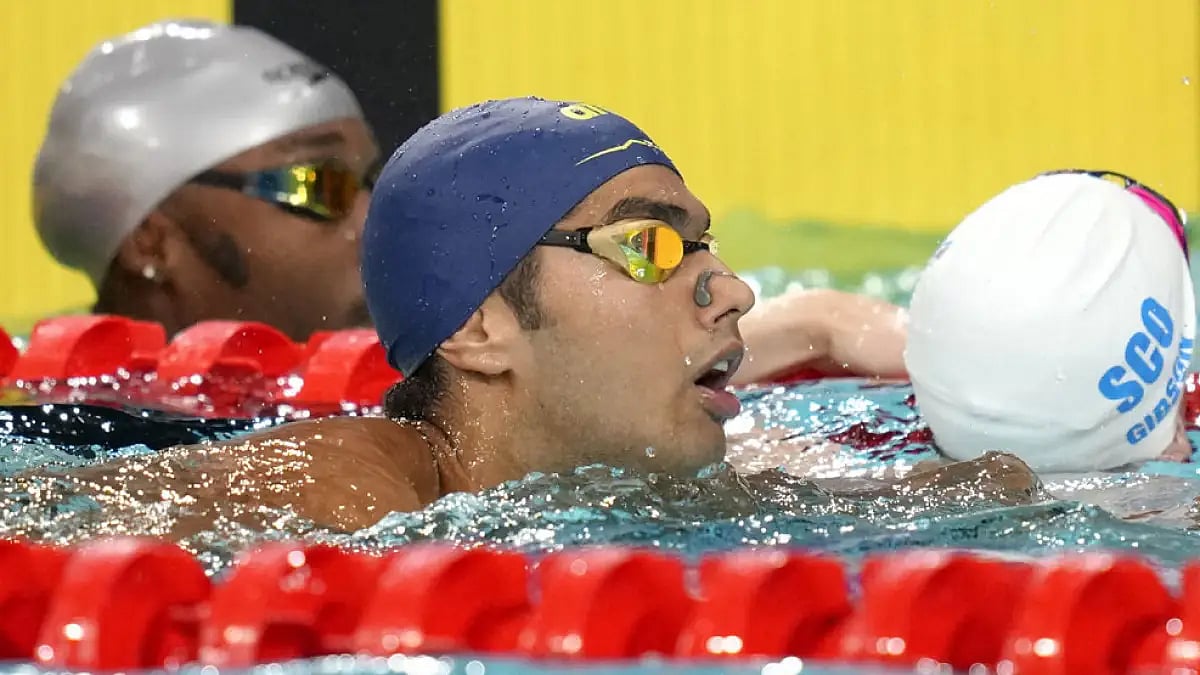 India's Srihari Nataraj, centre, after competing in the men's 50m backstroke heat at the Commonwealt