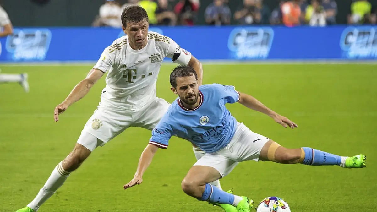FC Bayern Munich's Thomas Muller, left, and Manchester City's Bernardo Silva fight for the ball during a friendly match.