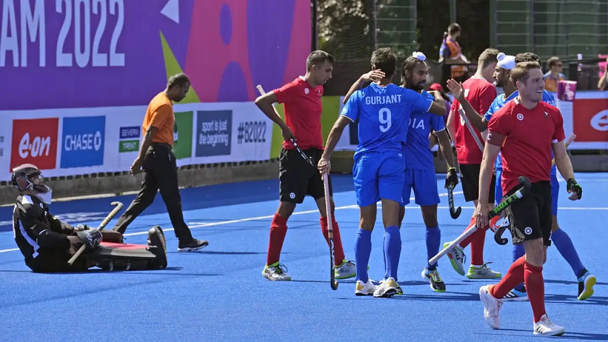 Indian players celebrate a goal against Canada during their hockey match.