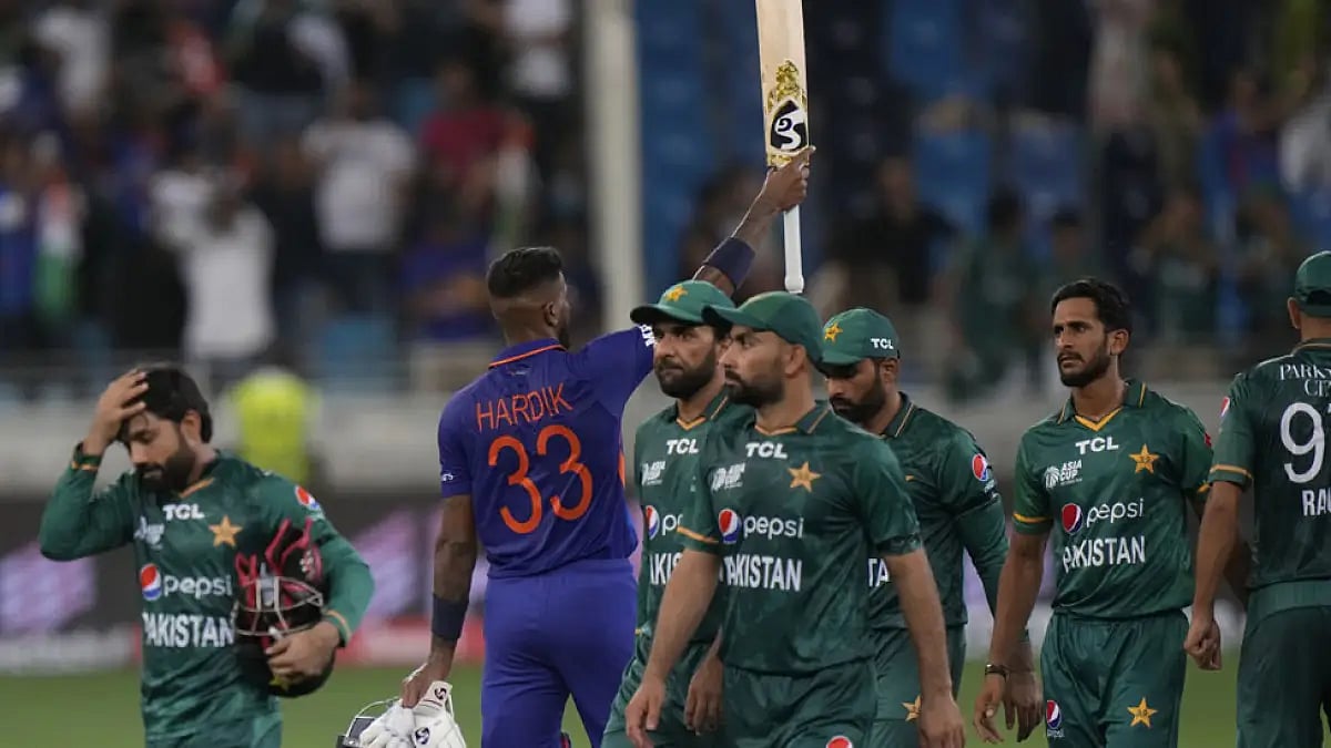 India's Hardik Pandya celebrates as Pakistan players leave the field.