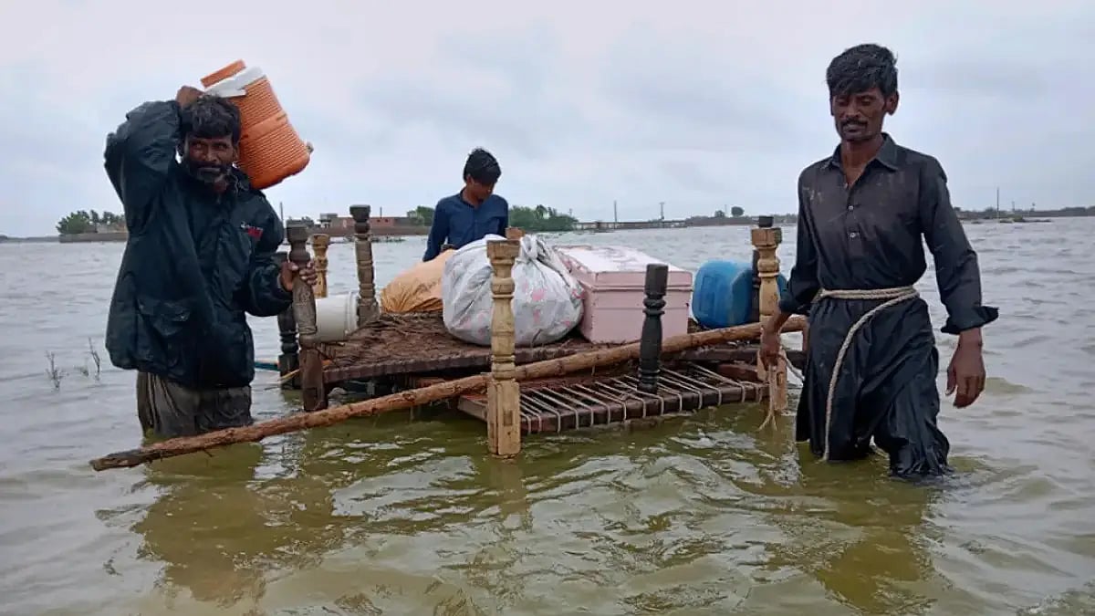 People use a cart to salvage usable items from their flood-hit homes in southern Pakistan 