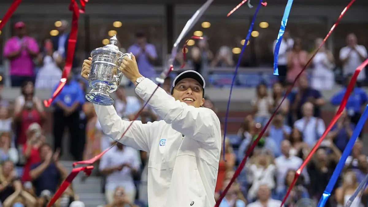 Iga Swiatek holds up the US Open trophy after defeating Ons Jabeur in 2022 final.