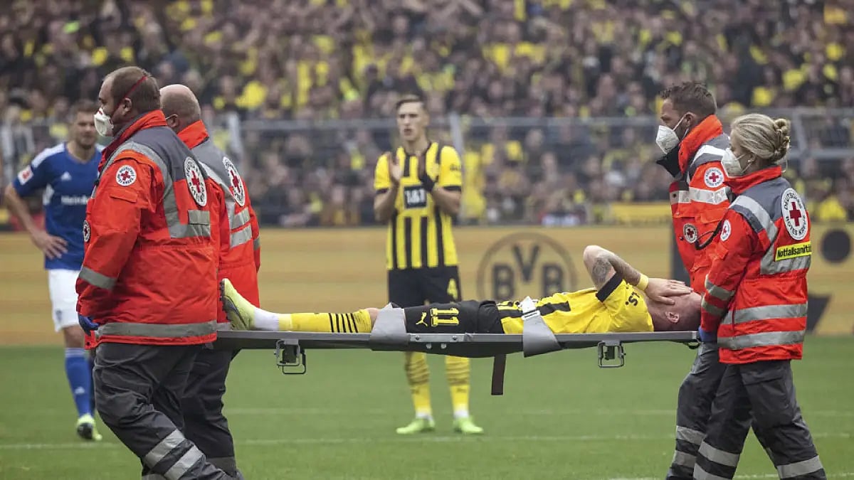 Borussia Dortmund's Marco Reus is carried off the pitch during their match against FC Schalke 04.