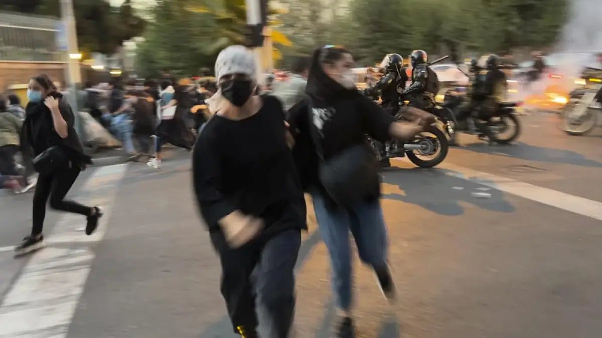 Women run away from anti-riot police during a protest 