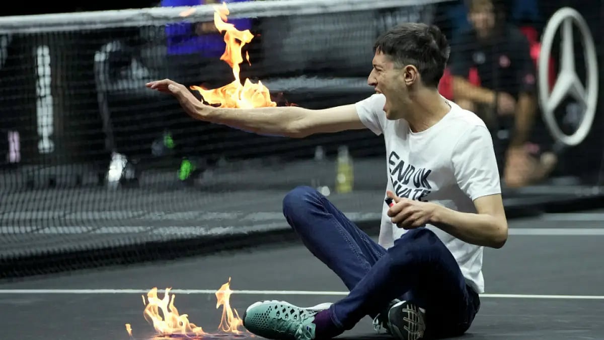 A man sets fire on his hand during a protest before the start of a Laver Cup tie on Friday.