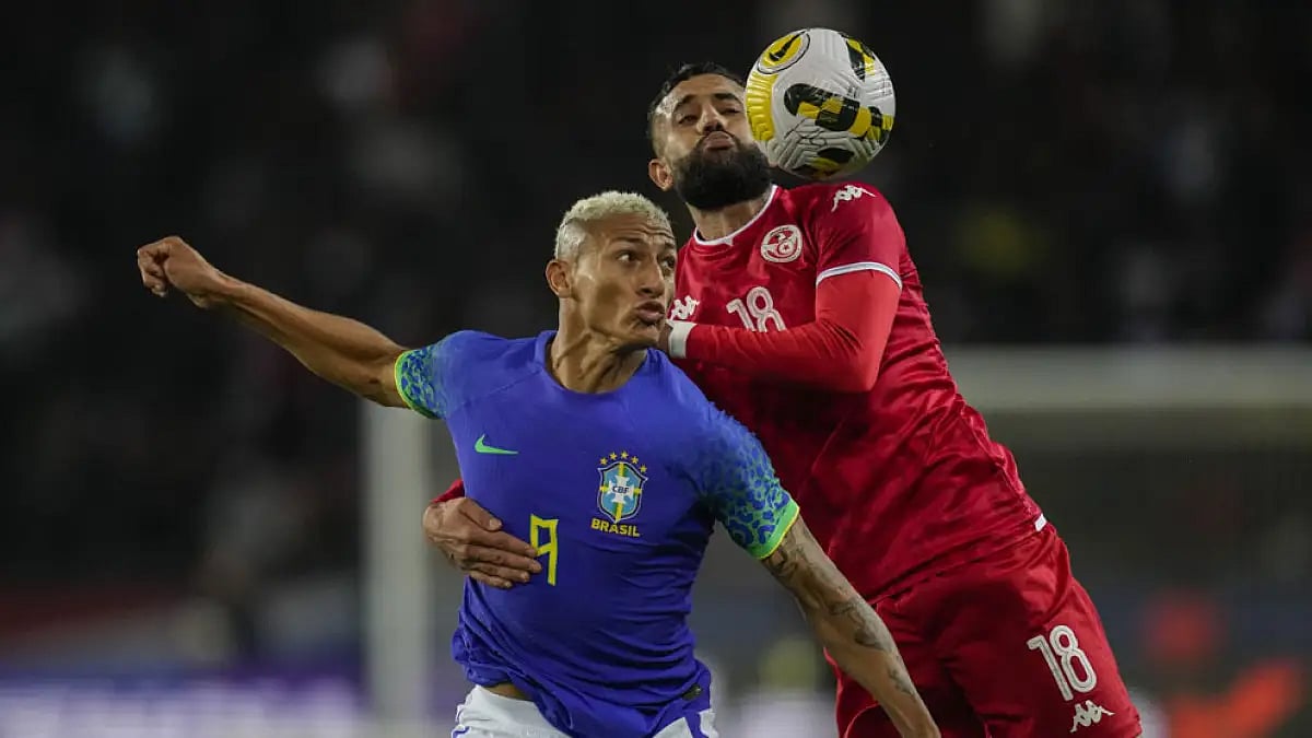 Tunisia's Ghaylen Chaaleli, right, duels for the ball with Brazil's Richarlison.