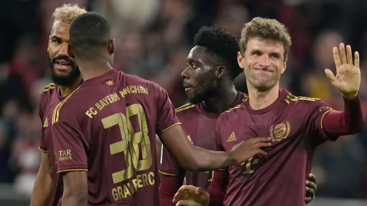 Bayern Munich's Thomas Mueller (R) celebrates after scoring against Bayer Leverkusen.