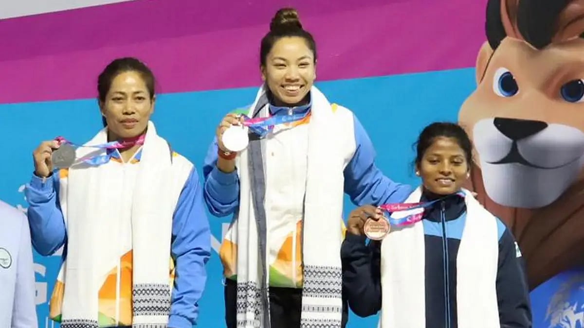 Saikhom Mirabai Chanu (C) poses atop the podium with the gold medal at National Games 2022.