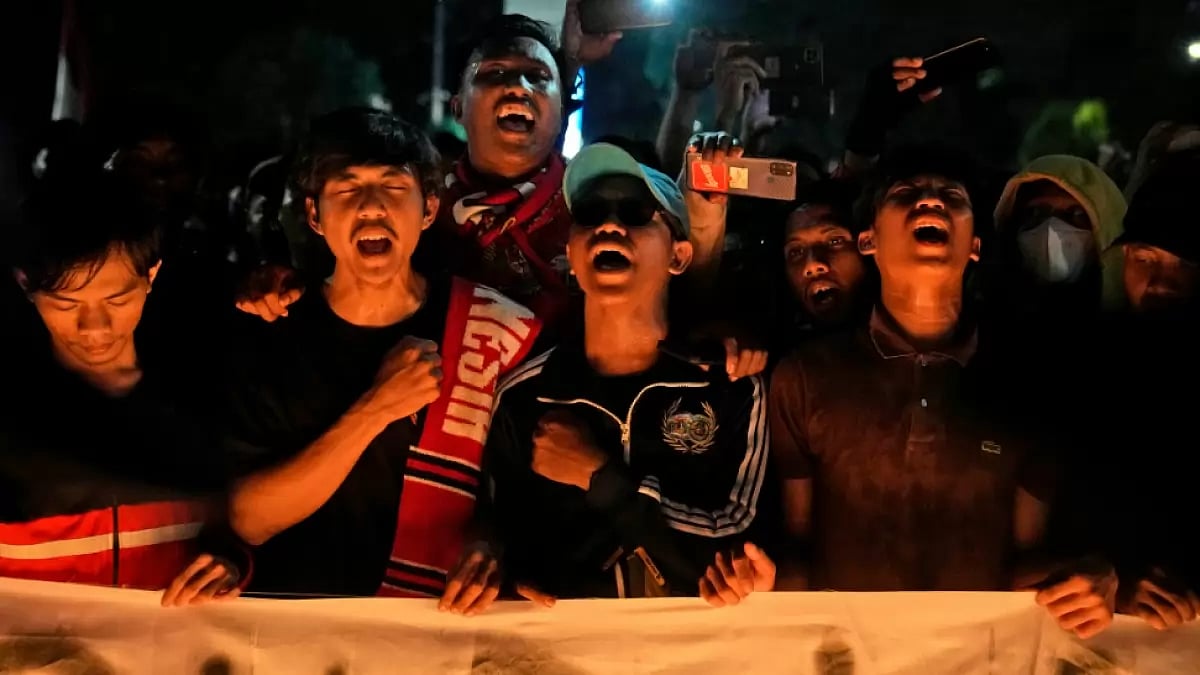 Fans chant slogans during a candle light vigil for the victims of Saturday's football riots in Jakar