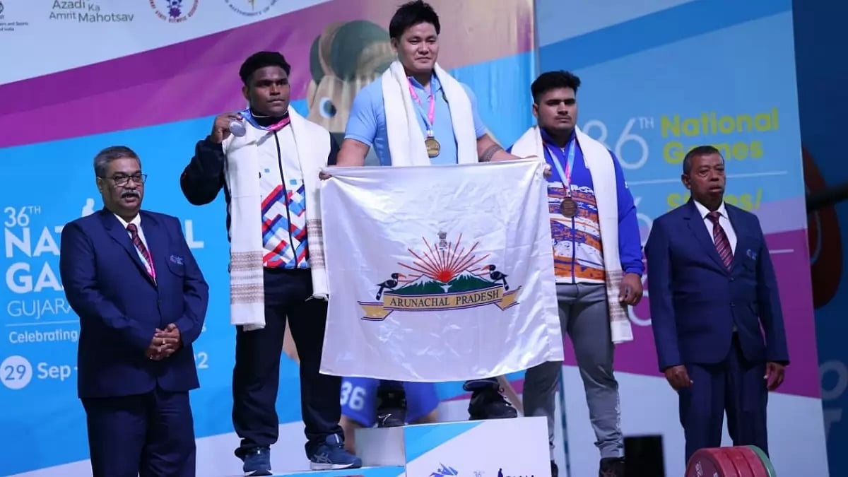 Sambo Lapung (with flag) poses for pictures during the medal ceremony at National Games 2022. 
