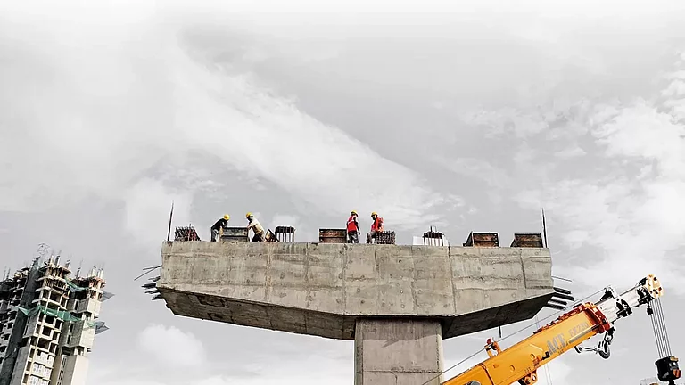 Urbanscape: Labourers surveying the construction work on top of a pillar - null