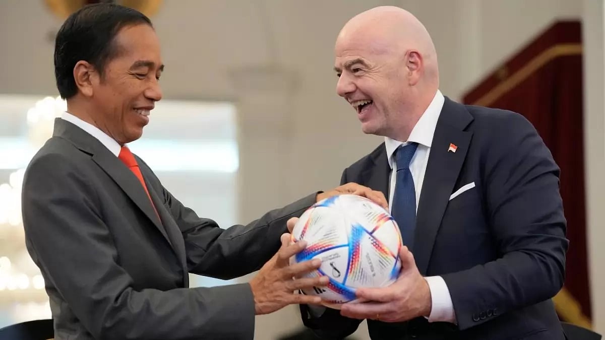 Indonesian President Joko Widodo, left, receives a gift of a ball from FIFA President Gianni Infanti