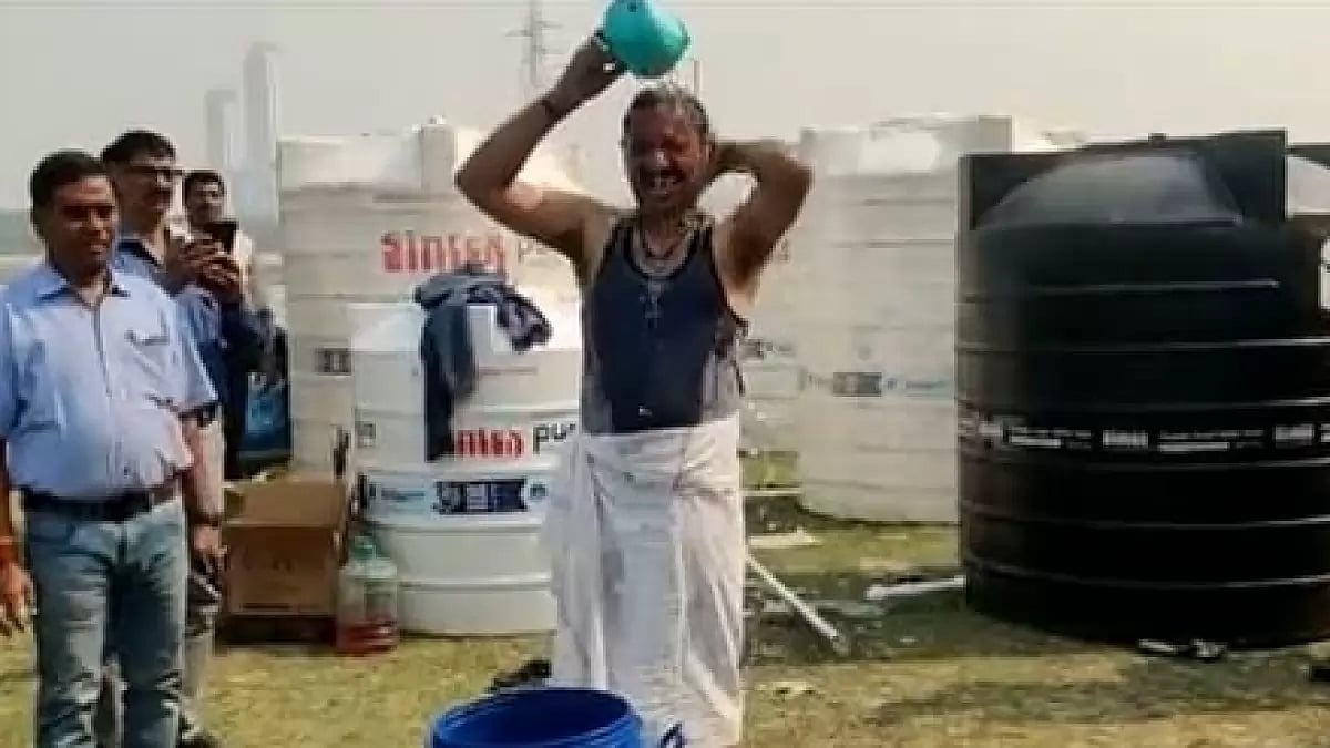 DJB official Sanjay Sharma bathing with Yamuna water