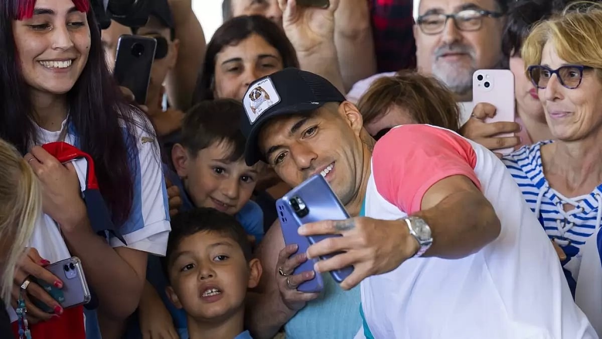 Uruguay's Luis Suarez takes pictures with fans.