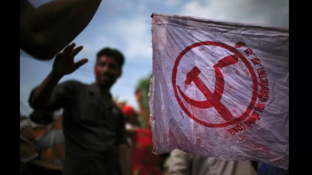 Nepali Maoists supporters dance and wave flags during a victory celebration