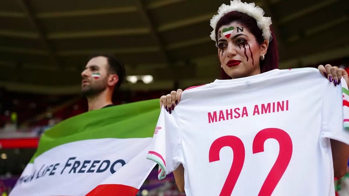 A fan holds a jersey with the name of Mahsa Amini, a woman who died while in police custody in Iran.