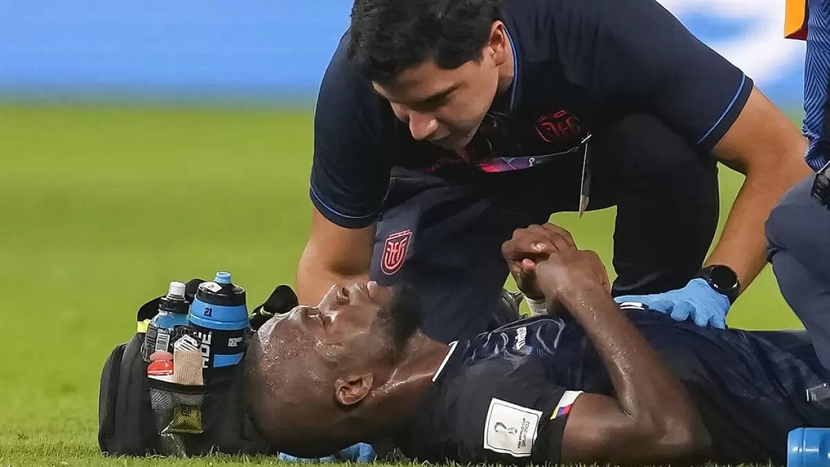 Enner Valencia is attended by a medical professional during a match against Netherlands.