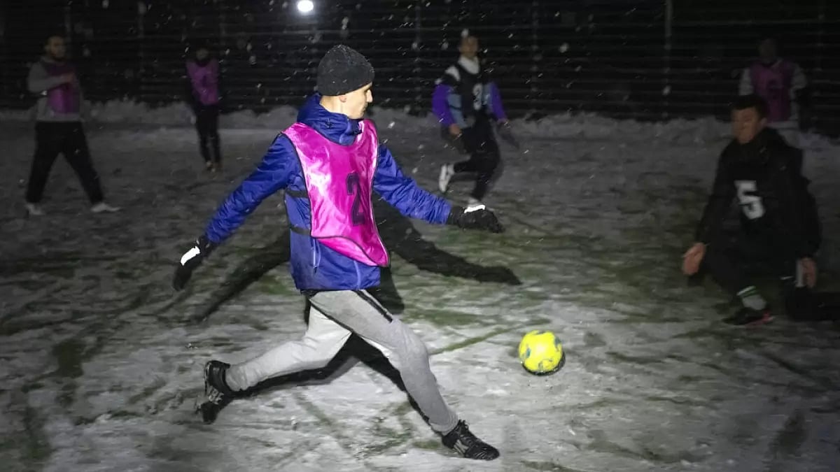 Men play football during a blackout in Irpin, Ukraine, on Tuesday.