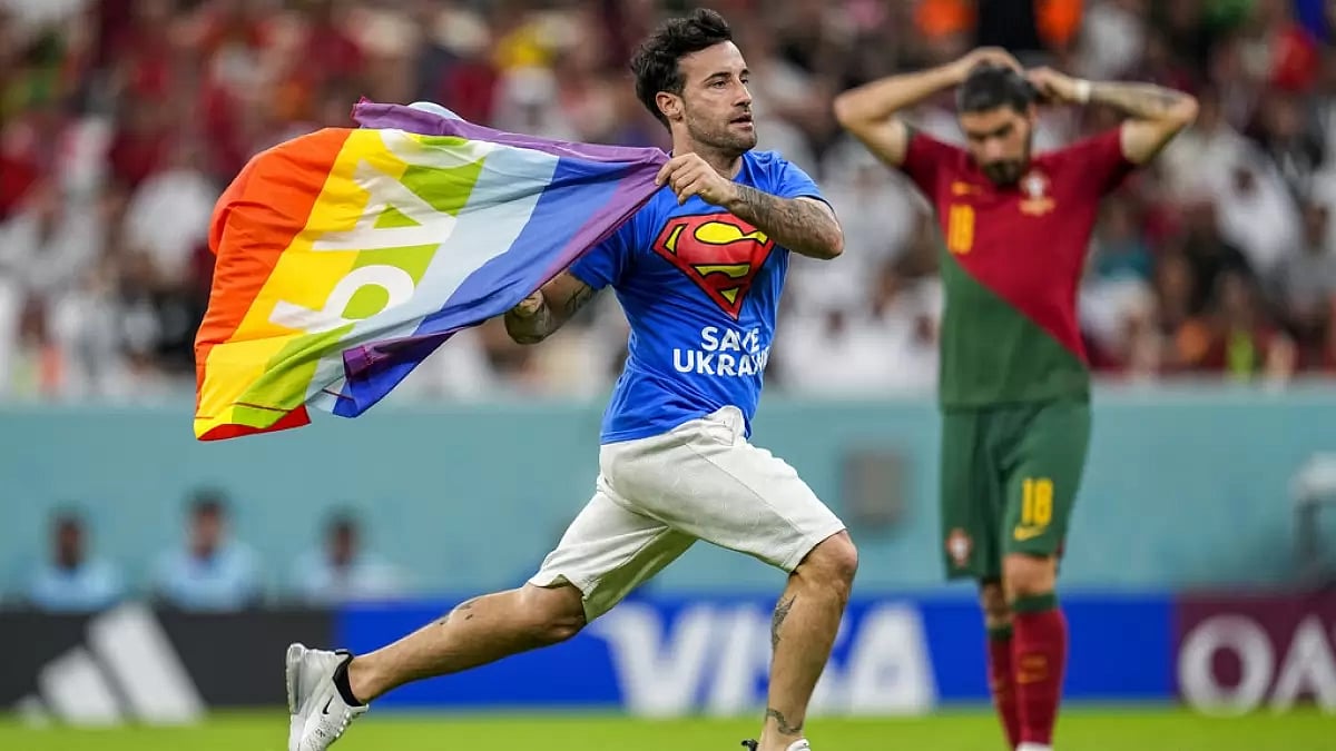 A pitch invader runs across the field during the match between Portugal and Uruguay.