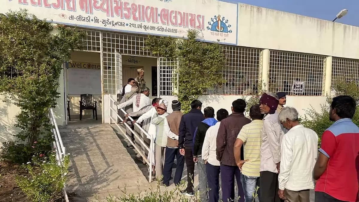 People wait in a queue to cast their votes during the first phase of Gujarat Assembly elections.
