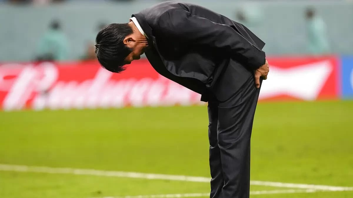 Japan's coach Hajime Moriyasu bows while acknowledging the fans after his team's loss to Croatia.