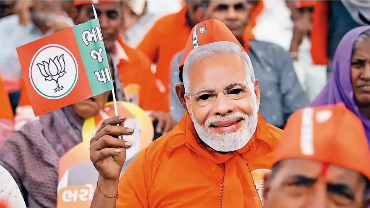A BJP supporter wears the mask of PM Modi during an election rally in Gujarat.