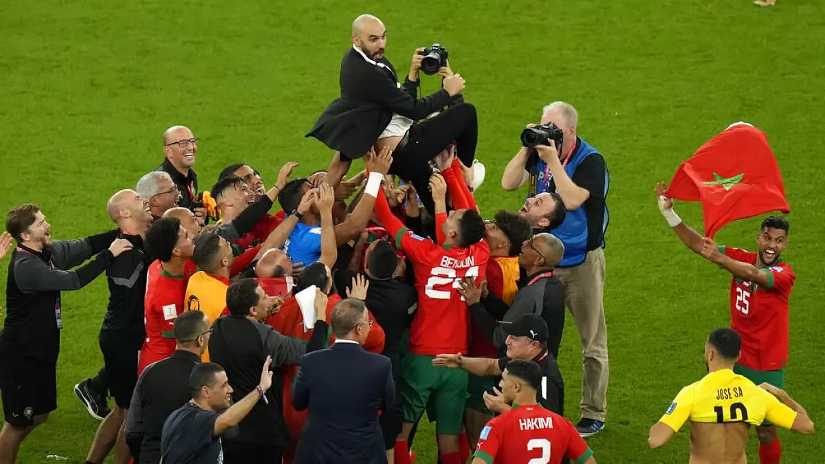 Morocco players celebrate with head coach Walid Regragui after win over Portugal on Saturday.