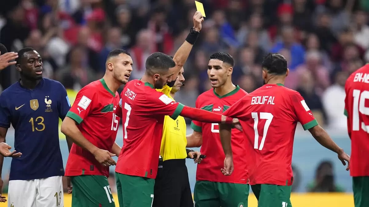 Referee Cesar Ramos shows a yellow card to Morocco's Boufal in the semifinal against France.