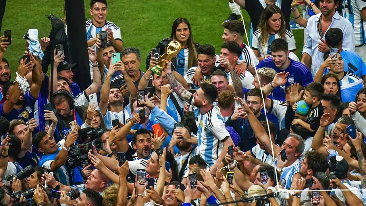 Argentina captain Messi holds the World Cup as he celebrates with teammates.