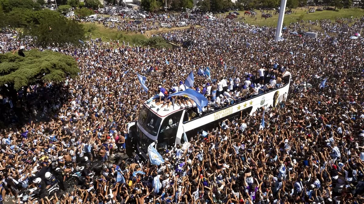 Argentina players ride on an open-top bus as they celebrate the World Cup victory with fans.