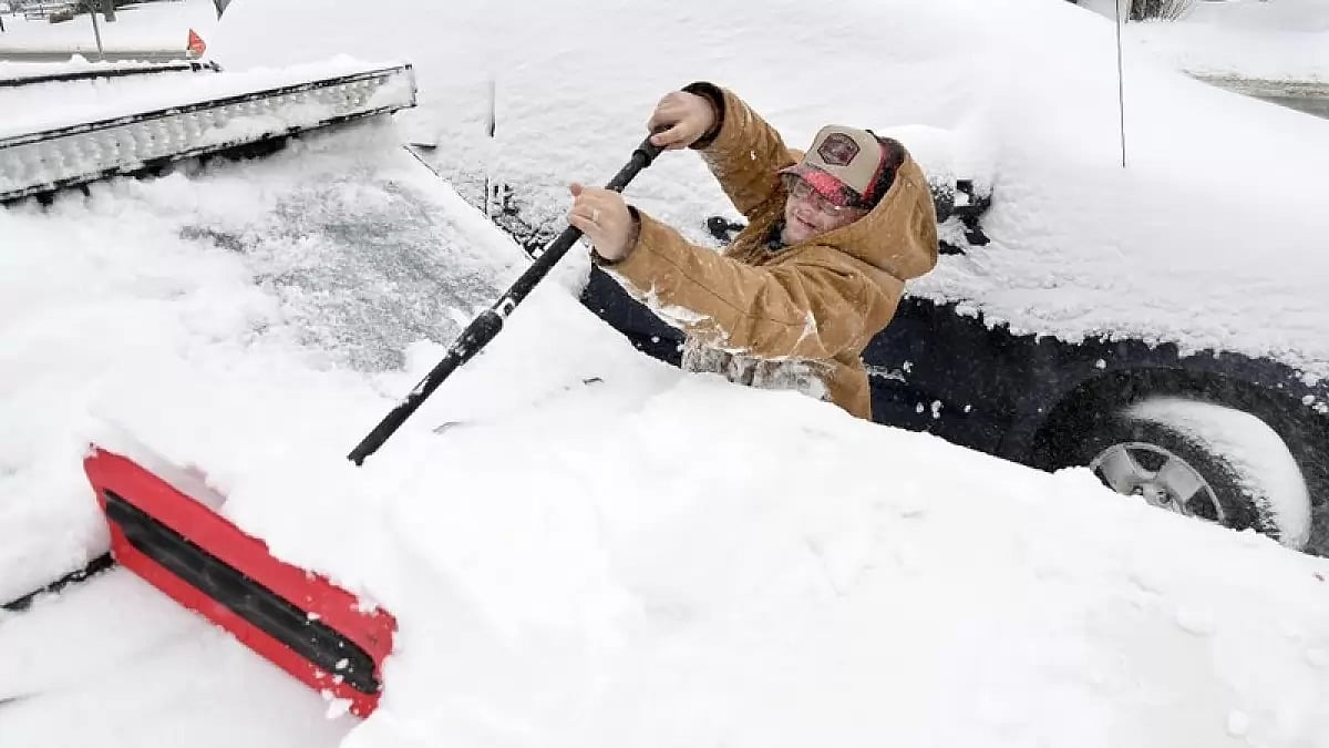 A man removes snow in South Street, Mass.