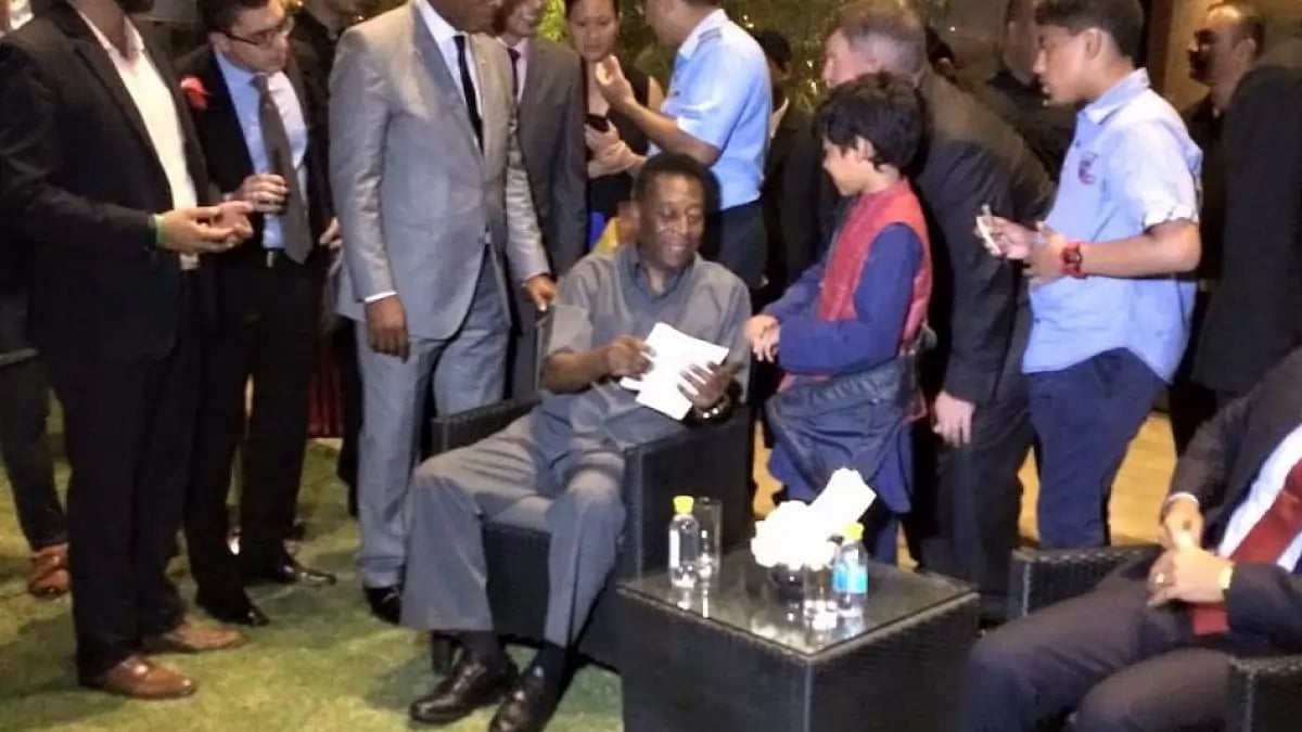 Pele interacts with a young football fan during his Delhi visit in 2015.