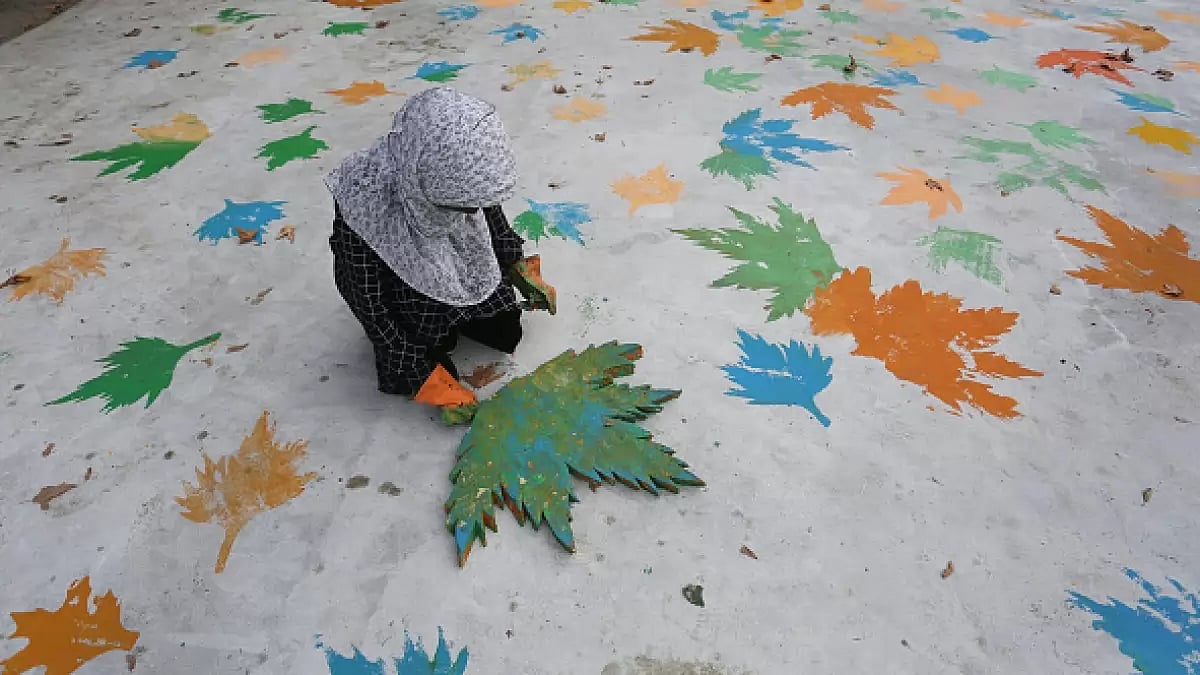 An artist paints on a road near Sher-e-Kashmir park under the Smart City Project in Srinagar.