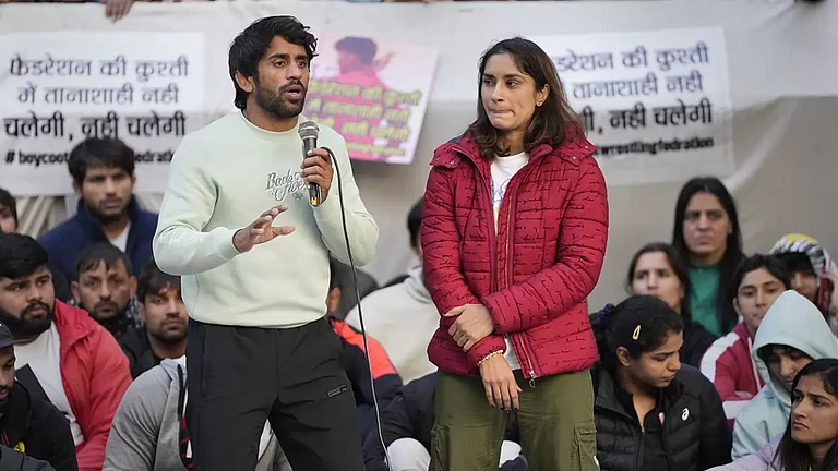 Bajrang Punia speaks as fellow wrestler Vinesh Phogat looks on during their protest against WFI. - PTI