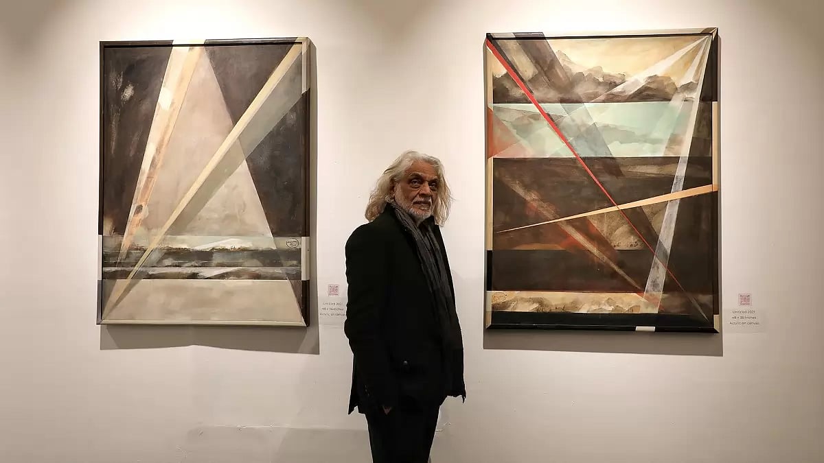 Painter and artist Muzaffar Ali against his landscapes at Bikaner House. 
