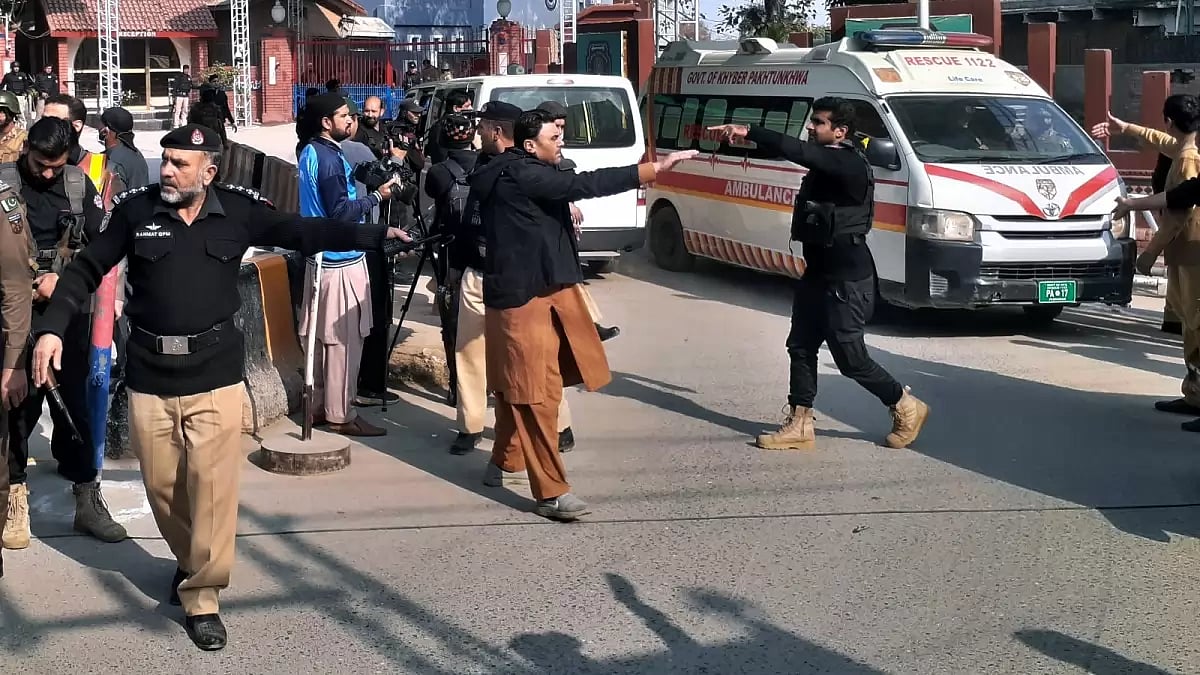 Police officers clear the way for ambulances leaving after carrying wounding people from bomb explosion site in Peshawar, Pakistan.