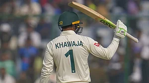 Khawaja raises his bat after reaching his fifty on Day 1 of the 2nd Test on Friday.