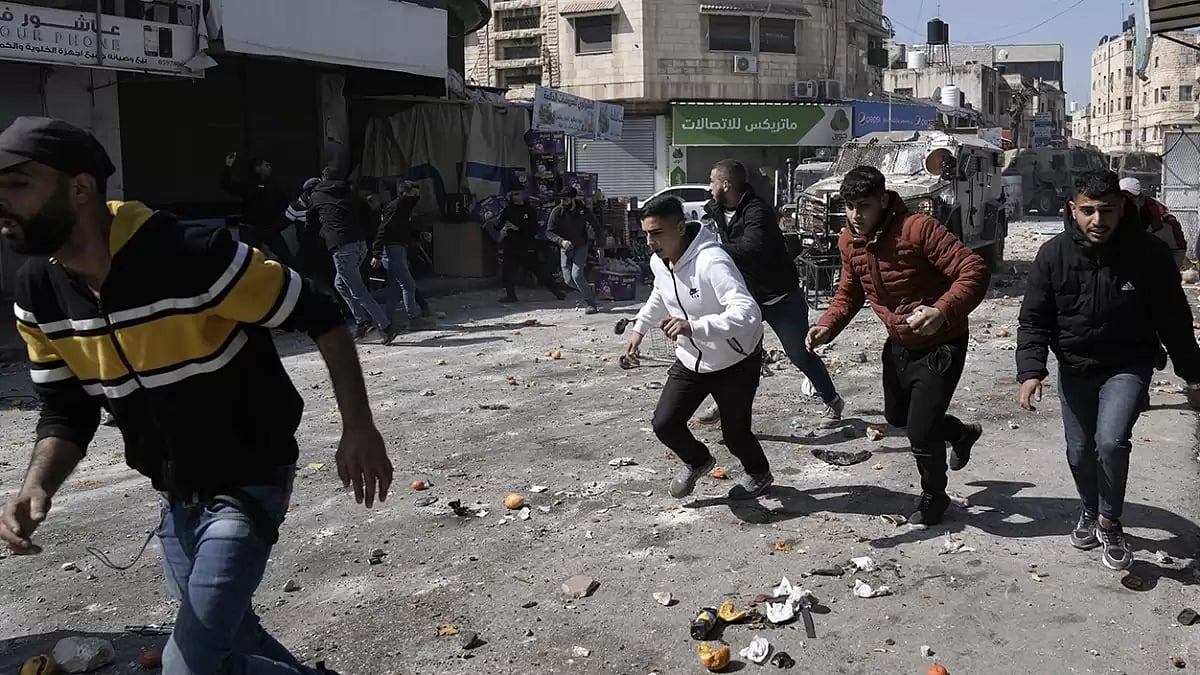Palestinians run during clashes with Israeli forces in the West Bank city of Nablus.