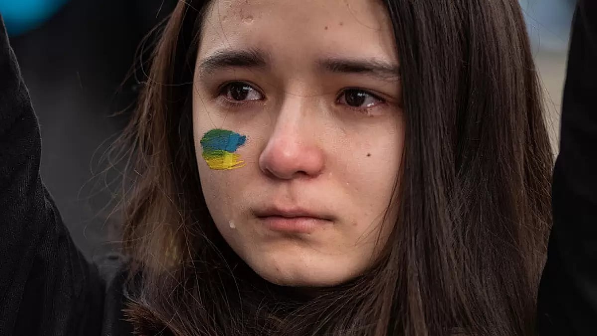 A young woman attending a demonstration in Mariupol's support cries at the Ukrainian national anthem