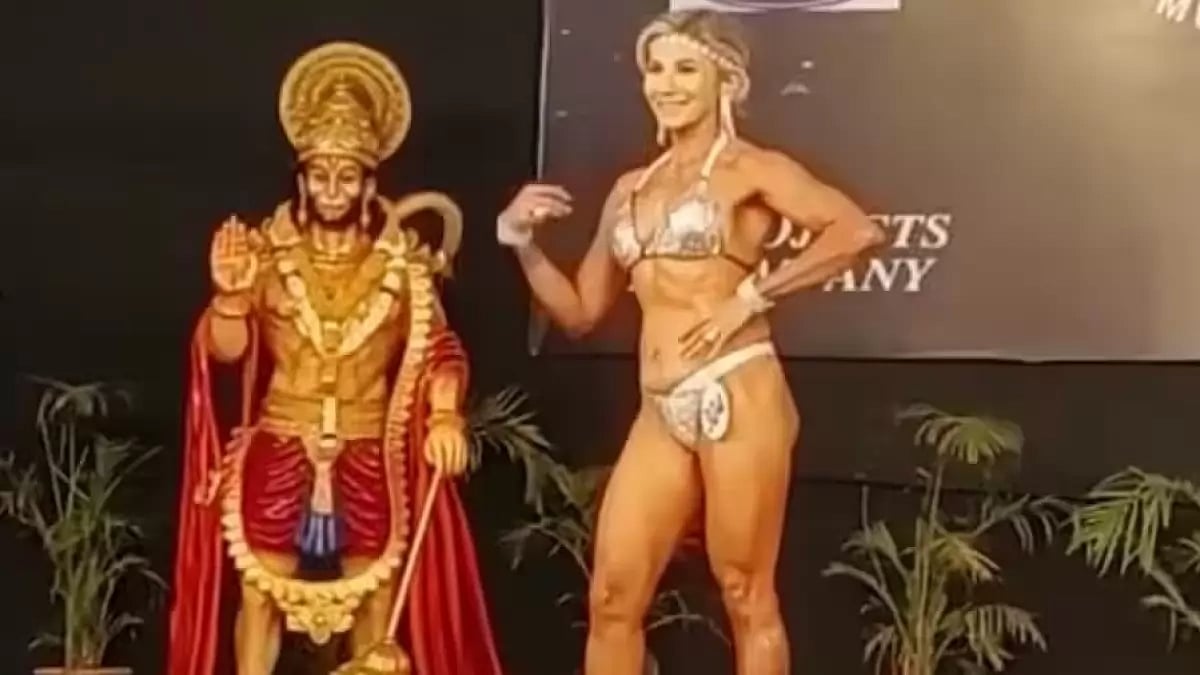 A woman bodybuilder posing in front of a cut-out of Lord Hanuman in Madhya Pradesh 