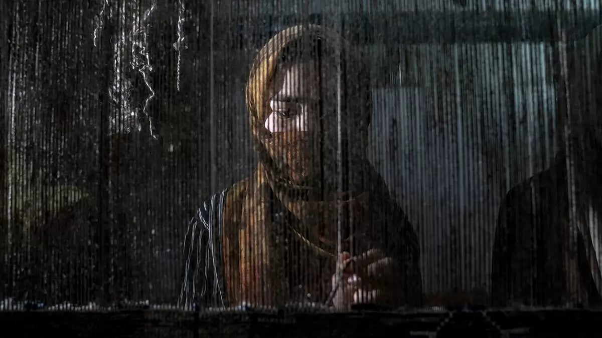 An Afghan woman weaves a carpet at a traditional carpet factory in Kabul, Afghanistan.