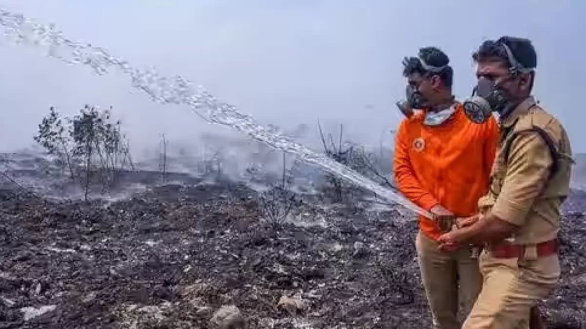 Fire and safety department officials at the Brahmapuram waste treatment plant in Kerala