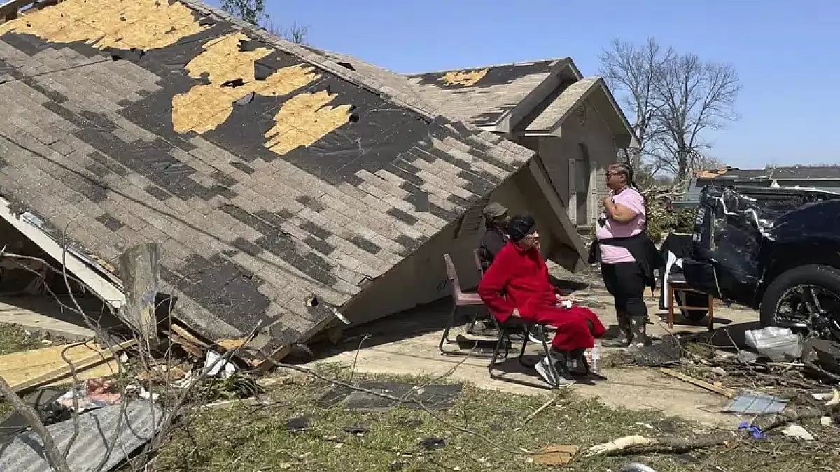 People in front of damaged houses after a deadly tornado rips through Mississippi