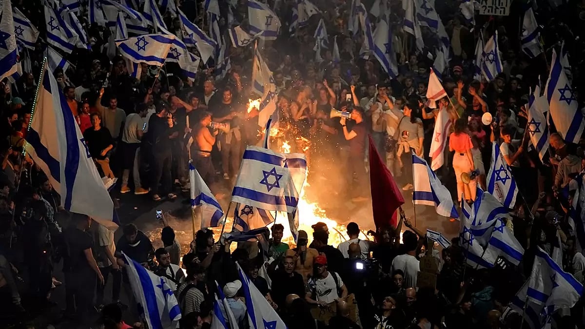 Israelis opposed to Prime Minister Benjamin Netanyahu's judicial overhaul plan set up bonfires and block a highway during a protest moments after the Israeli leader fired his defense minister, in Tel Aviv, Israel.