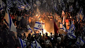 Israelis opposed to Prime Minister Benjamin Netanyahu's judicial overhaul plan set up bonfires and block a highway during a protest moments after the Israeli leader fired his defense minister, in Tel Aviv, Israel.